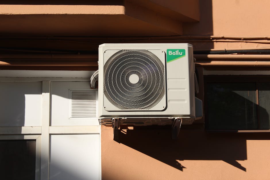 A modern ductless mini-split condenser mounted on the exterior of a home